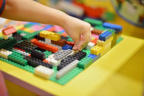 childs hand playing with legos